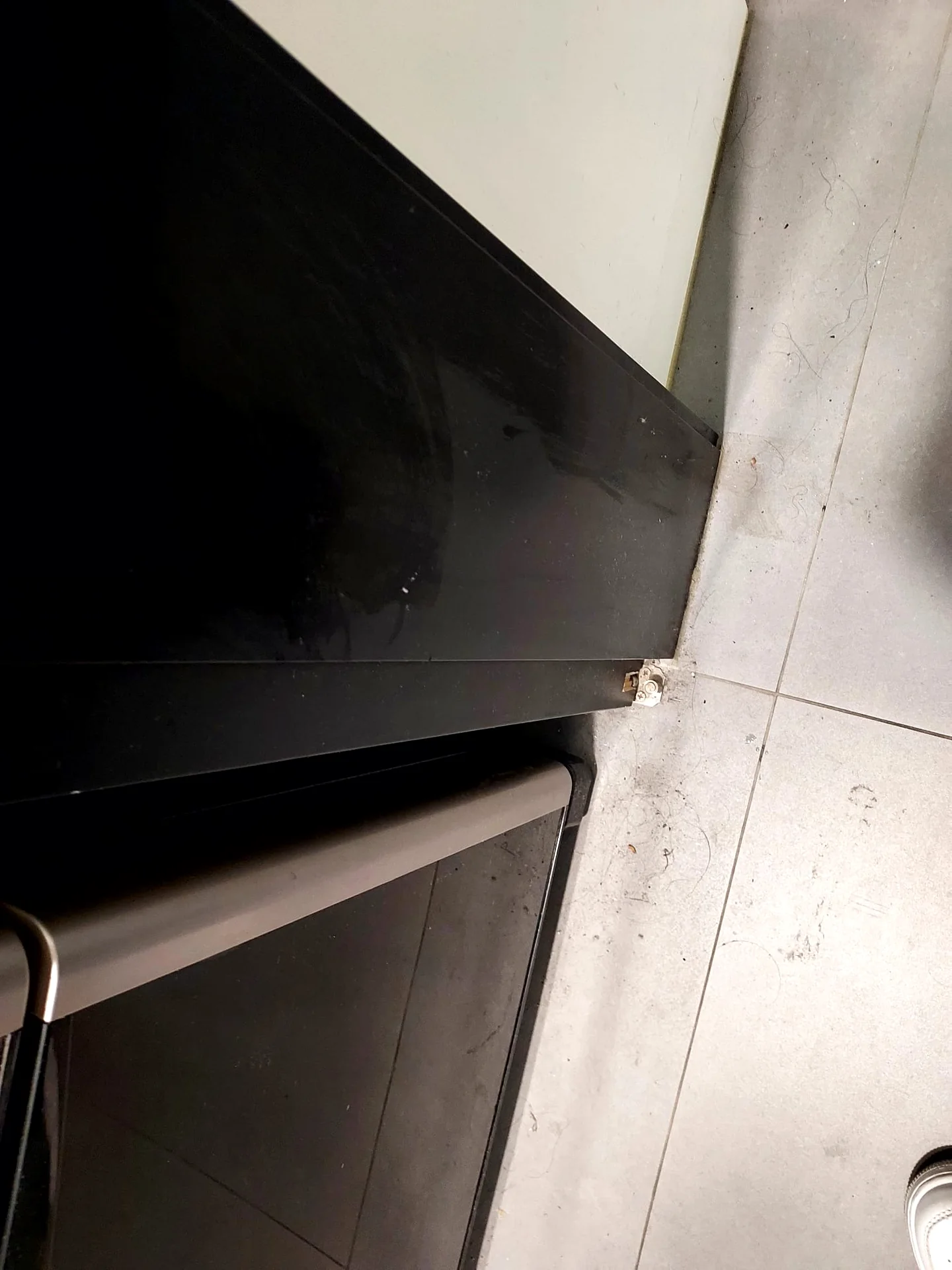 家電側邊與地磚交界可見毛髮及碎屑