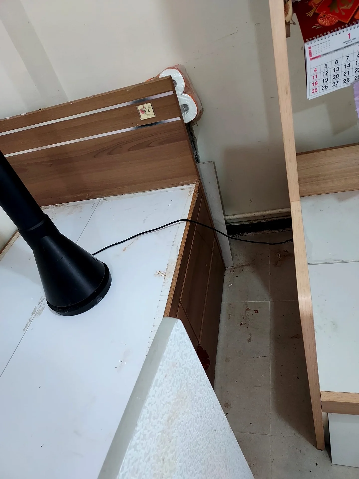 兩件傢俬之間的窄道及牆腳,地面可見碎屑