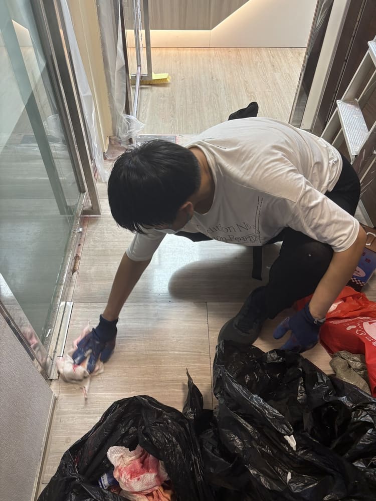 工作人員擦洗玻璃門旁地面