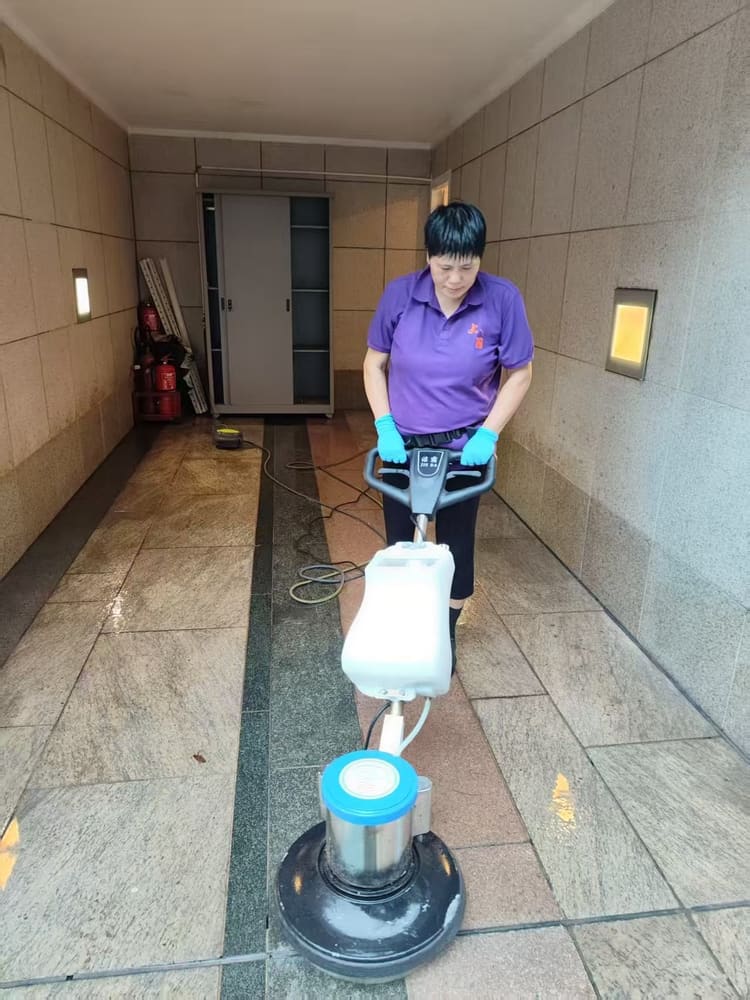 制服工作人員操作洗地機清潔走廊