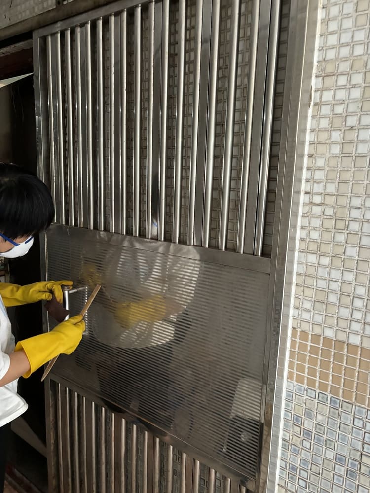 戴手套擦洗鐵閘表面